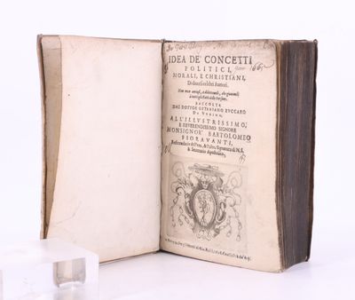 un livre ouvert posé sur une table blanche, à côté d'un bloc de glace