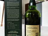 a bottle of whisky sitting on a table next to a box