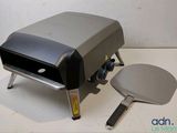 an image of a pizza oven with a pizza cutter on it