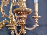 a gold colored chandelier with two candles on it