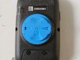 a black cell phone with a blue button on it