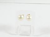une paire de boucles d'oreilles en perles posée sur une vitrine transparente