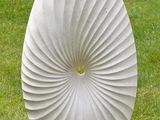 a white sculpture on a white base in the grass