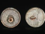 pair of silver and gold earrings on a black surface
