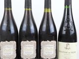 quatre bouteilles de vin sont alignées sur une table