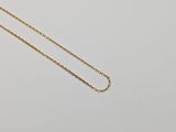 a gold chain necklace with a single diamond on a white background