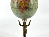 une statue représentant un homme tenant un globe terrestre, posée sur un socle
