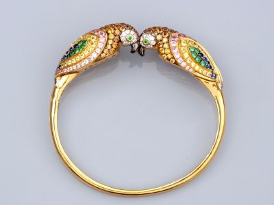 une image montrant un gros plan d'une bague ornée de deux perroquets