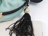 a purse with a tassel hanging from it ' s handle