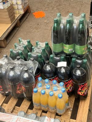 de nombreuses bouteilles de soda posées sur une palette dans un magasin