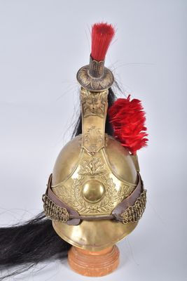 un casque doré orné d'une plume rouge