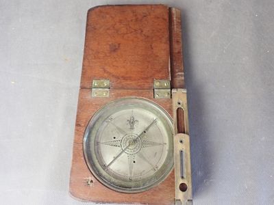 une petite boîte en bois sur laquelle est représenté un compas