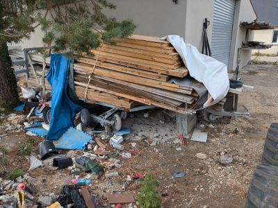 un tas de bois posé sur le sol à côté d'un bâtiment