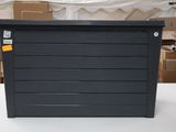 a black box sitting on a table with boxes in the background