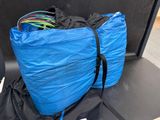 a blue bag filled with wires on the back of a car