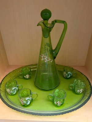 a green glass pitcher and cups on a green tray