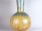 a yellow and blue vase sitting on a white surface