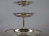 a silver three tiered cake stand on a table