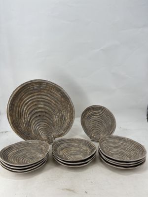 six plates and a bowl sitting on a table with a vase in the background