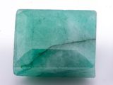 a close up of a green stone on a white surface