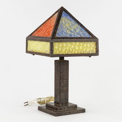 un gros plan d'une lampe posée sur une table, dont le cordon est branché