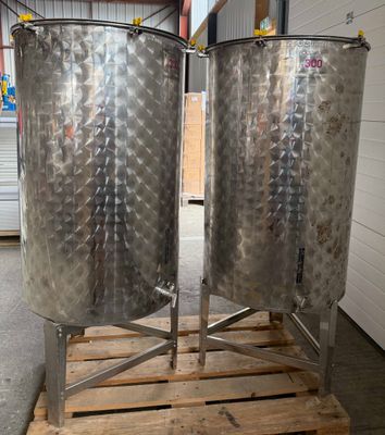 deux grandes cuves en acier inoxydable posées sur une palette en bois