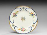 une assiette décorée de fleurs et de feuilles sur fond blanc