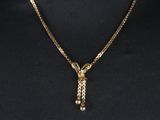 un collier en or muni d'une chaîne qui y est attachée