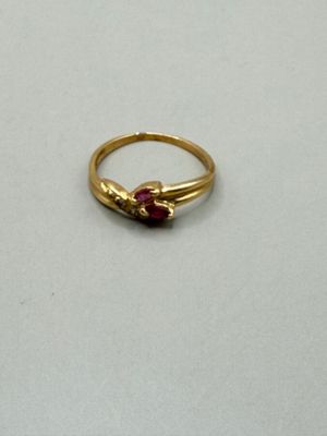 an image of a gold ring with a red stone
