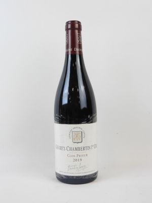 une bouteille de vin rouge posée sur une table blanche