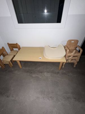 plusieurs chaises en bois et une table dans une pièce dotée d'une fenêtre