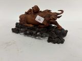 une figurine représentant un éléphant et un éléphanteau posés sur un tas de pierres noires