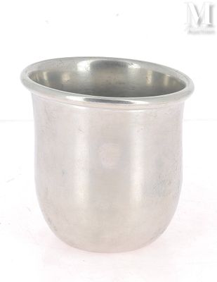 une tasse en argent posée sur une surface blanche