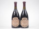 two bottles of wine sitting next to each other on a white surface
