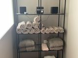Des serviettes sont empilées sur une étagère dans une salle de bains dotée d'une fenêtre