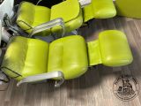 three green leather reclining chairs sitting on a hard wood floor