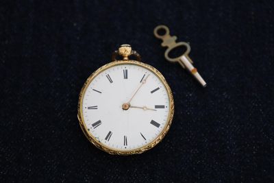 une montre à gousset en or à laquelle est attachée une clé