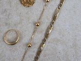 un collier, un bracelet et une bague en or posés sur une table