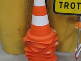 a pile of traffic cones and a sign on the ground