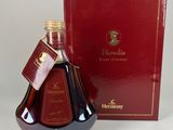 une image représentant une bouteille de brandy posée à côté d'une boîte rouge