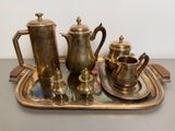 a tray that has a silver tea set on it