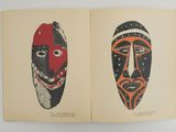 un livre ouvert sur lequel sont posés deux masques de couleurs différentes