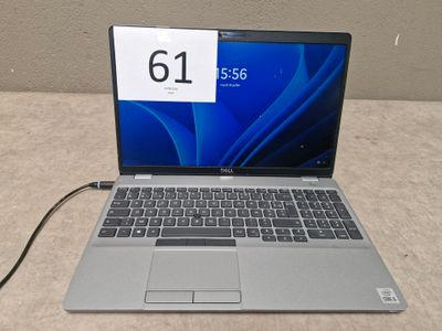 un ordinateur portable ouvert posé sur une table à côté d'un chargeur