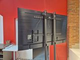 a television that is on a stand in front of a red wall