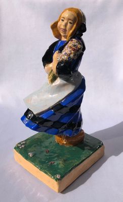 figurine of a woman with a basket of flowers on a book