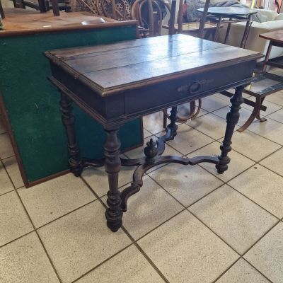 a table with a wooden top on a tile floor