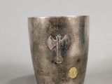 a silver cup with a key in it on a table