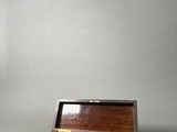 an old wooden box sitting on top of a white surface
