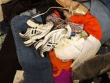 a person sitting on a bed with a pile of clothes
