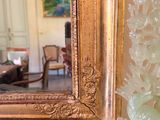 a vase with flowers in front of a mirror